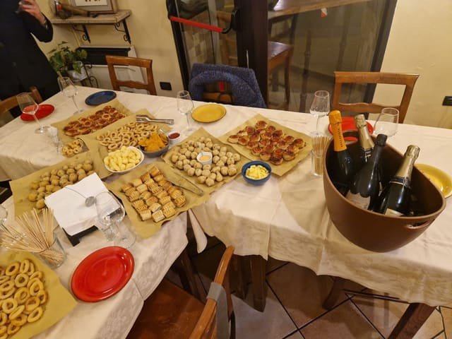 Tavolate apparecchiate con buffet salato e secchiello di bollicine