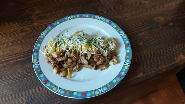 Tagliatelle con funghi, pancetta e formaggio grattugiato